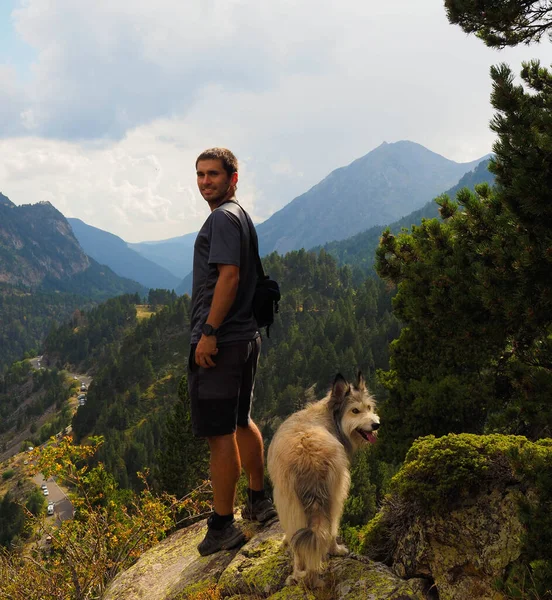 ユスカの犬と一緒に山の頂上にいる若い男 — ストック写真