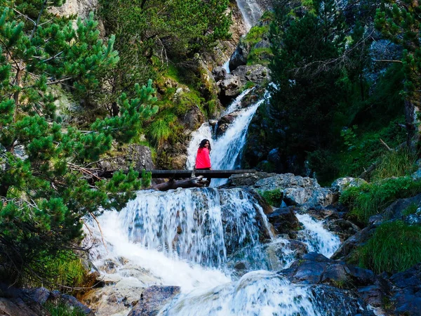 young woman with a waterfall in the mountains