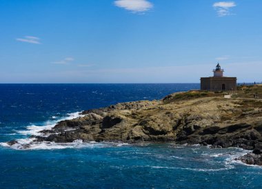 Costa Bravo 'daki deniz feneri mavi gökyüzü ve dalgalarıyla