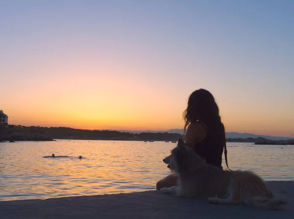 Costa Bravo 'da köpeğiyle birlikte genç bir kadının silueti.