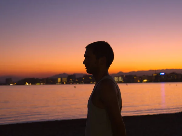 Gün batımında güller içinde genç bir adamın portresi.