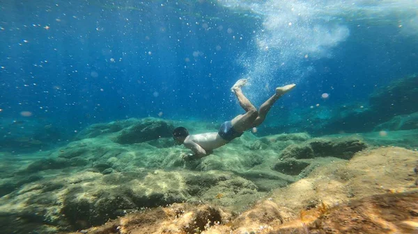 Costa Bravo 'da şnorkelle yüzen genç adam.