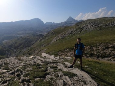 Genç adam dağ yürüyüşü yapıyor.