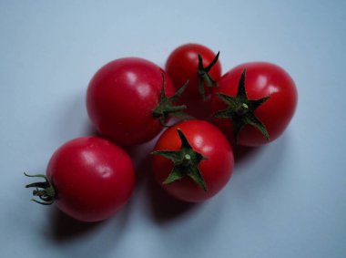 Beyaz bir masada izole edilmiş kiraz domatesleri.