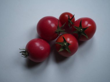 Beyaz bir masada izole edilmiş kiraz domatesleri.