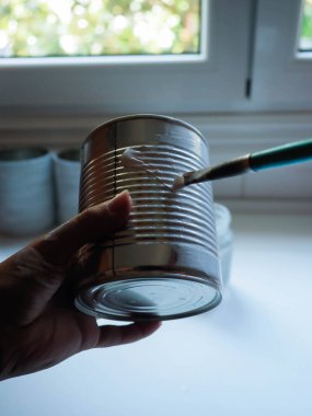 Metal kutu boyayan genç bir kadının eli