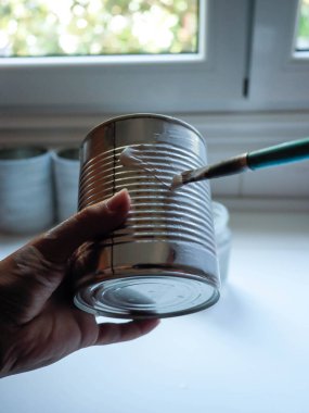 Metal kutu boyayan genç bir kadının eli