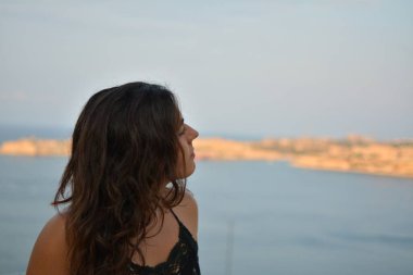 MALTA 'da gün batımını izleyen genç bir kadın.