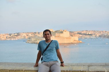 Genç adam MALTA 'da gün batımını izliyor.