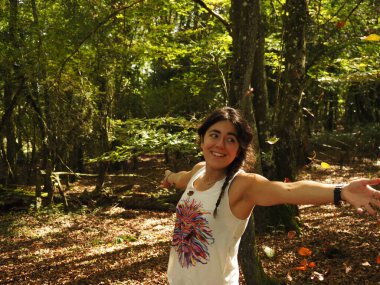 Parka yaprak atan genç bir kadın.