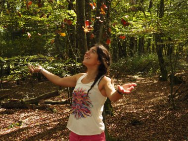 Parka yaprak atan genç bir kadın.