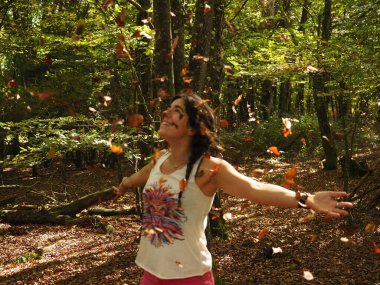 Parka yaprak atan genç bir kadın.