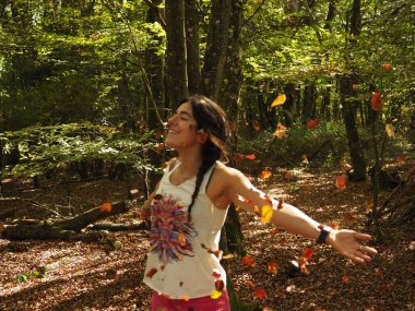 Parka yaprak atan genç bir kadın.