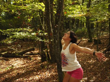 Parka yaprak atan genç bir kadın.