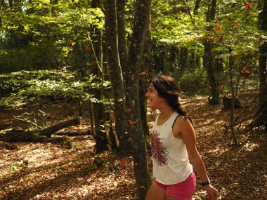 Parka yaprak atan genç bir kadın.