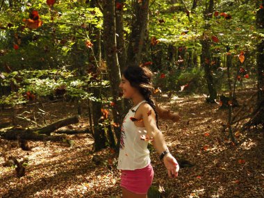 Parka yaprak atan genç bir kadın.