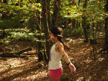 Parka yaprak atan genç bir kadın.