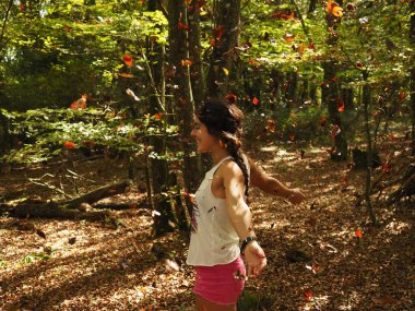 Parka yaprak atan genç bir kadın.