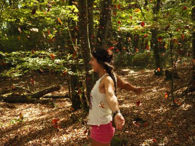 Parka yaprak atan genç bir kadın.