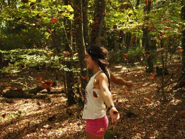 Parka yaprak atan genç bir kadın.