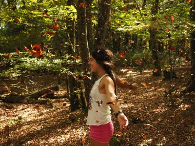 Parka yaprak atan genç bir kadın.