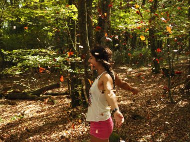 Parka yaprak atan genç bir kadın.