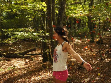 Parka yaprak atan genç bir kadın.