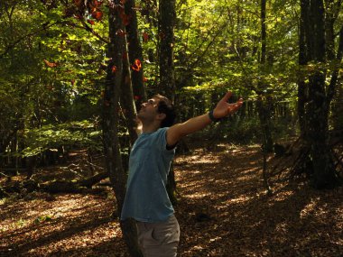 Parka yaprak atan genç adam.