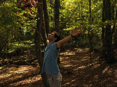 Parka yaprak atan genç adam.