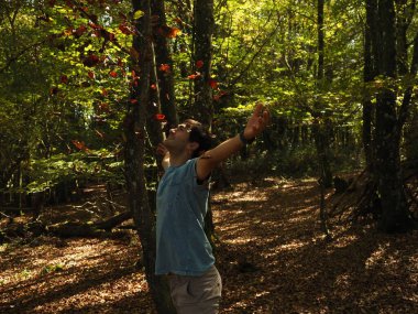 Parka yaprak atan genç adam.