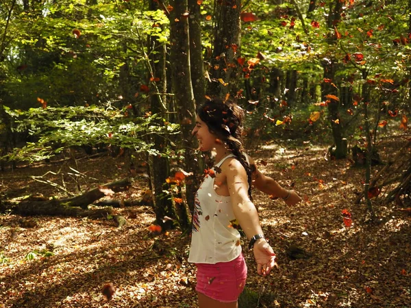 Parka yaprak atan genç bir kadın.