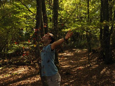 Parka yaprak atan genç adam.