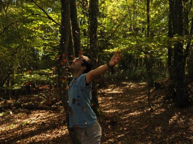 Parka yaprak atan genç adam.