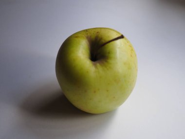 İzole edilmiş yeşil elma beyaz bir masada