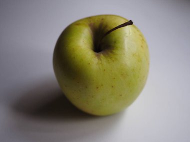 İzole edilmiş yeşil elma beyaz bir masada