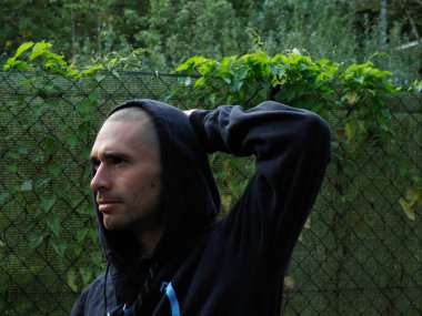 Parktaki kapüşonlu genç adam.