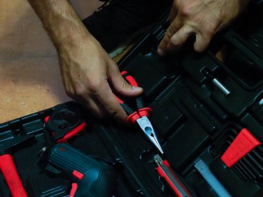 Alet kutusundan alet alan bir adamın eli.