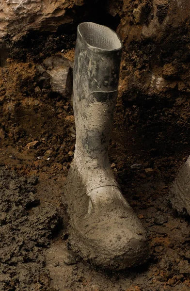 an isolated dirty wellington boot on a contruction
