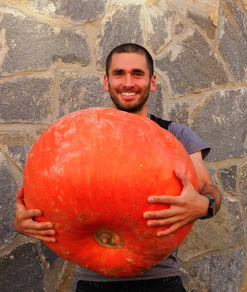 Junger Mann Mit Einem Großen Halloween Kürbis — Stockfoto