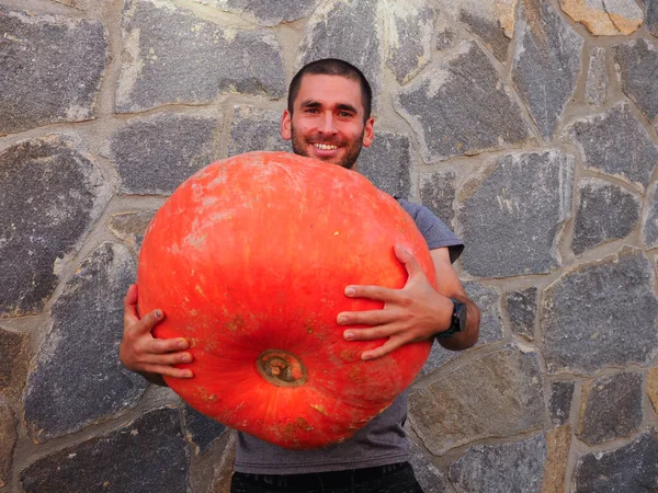 Junger Mann Mit Einem Großen Halloween Kürbis — Stockfoto