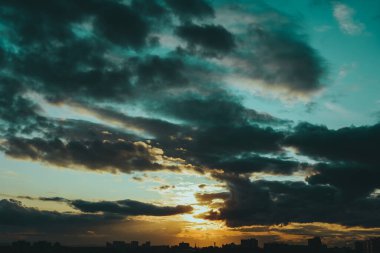 Bulutlar ve Karanlık Binalar siluetleriyle Parlak Dramatik Gökyüzü. 