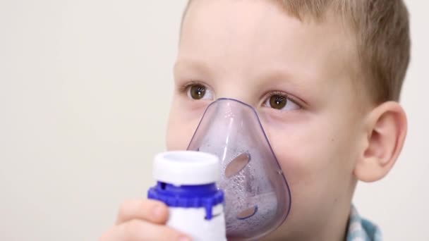El niño respira con un inhalador con máscara. Tratamiento de la enfermedad pulmonar crónica. Dificultad para respirar en los niños. Infección viral — Vídeos de Stock