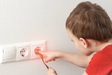 Yürümeye başlayan çocuk elektrik prizine dokunuyor. Evde elektrikle oynanan tehlikeli çocuk oyunları