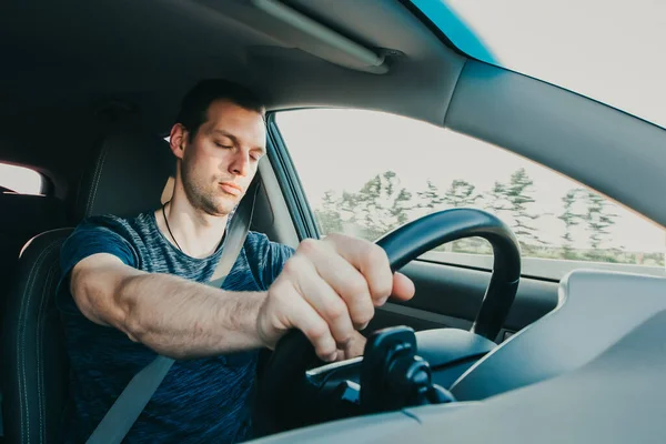 Müder Fahrer schläft während Autofahrt ein Schläfriger Mann mit Sicherheitsgurt im Fahrzeug. Unfallgefahr durch Alkoholvergiftung. Unsichere Fahrweise aufgrund von Müdigkeit oder Trunkenheit — Stockfoto