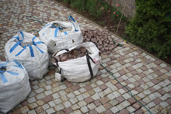 big bags of granite cube in a paved yard