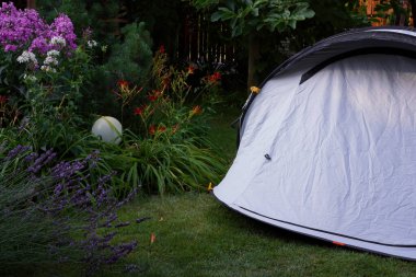 Sabah bahçenin çimlerine kurulmuş parlak mavi bir çadır.