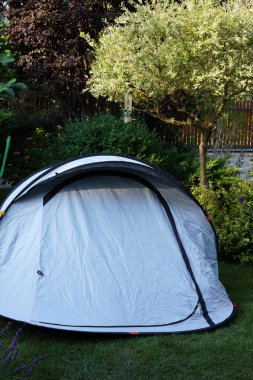 Sabah bahçenin çimlerine kurulmuş parlak mavi bir çadır.