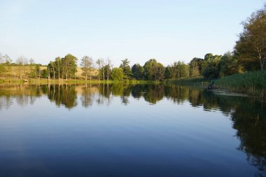 Przyton, Polonya - 18 Ağustos 2020: Göl kıyısı ve iskelede balıkçı