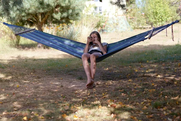 Een Meisje Een Hangmat Maakt Gebruik Van Een Smartphone Zomer — Stockfoto