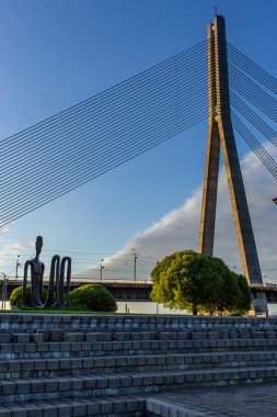 Riga, Letonya - 29 Haziran 2019: Metal oturan insanlar heykeli, başkent köprüsü